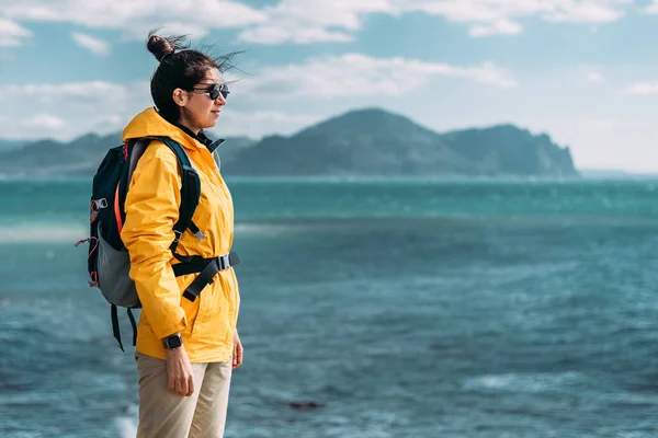 彼の観光バックパックを持つ旅行者の海の背景に立っている アクティブなライフスタイルの概念 青い海を背景にした女性旅行者の肖像画 スペースのコピー — ストック写真