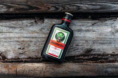 Chelyabinsk, Russia - July 30, 2021: Jagermeister bottle on a wooden background. Bottle of Jagermeister, German digestif made with 56 herbs. Jagermeister herb liqueur bottle. Jagermeister