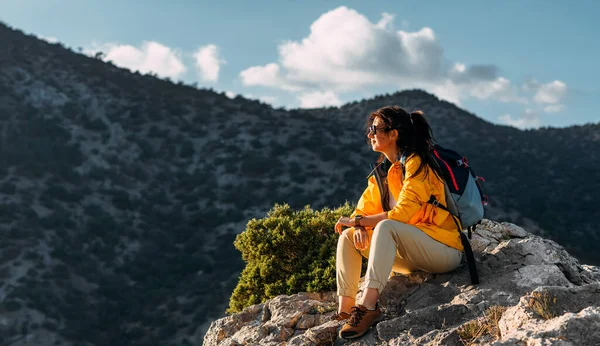 山の中で女性旅行者の肖像画 ハイキングのコンセプト 幸せな女性は山の中でハイキング中に日光を楽しんでいます リュックを持って山への旅 — ストック写真