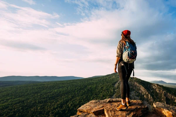 一位背着背包的女游客欣赏山顶上的落日 高山背景下的旅行者 一个背包客站在山顶上 全景尽收眼底 — 图库照片