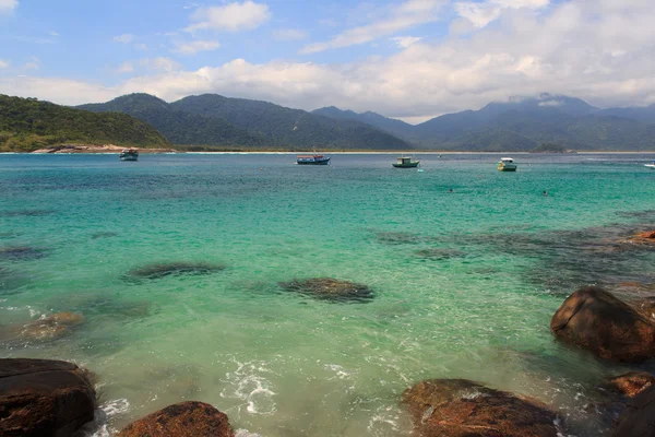 Båtar i öppet vatten med stranden aventueiro över ön ilha grande, brazil — Stockfoto