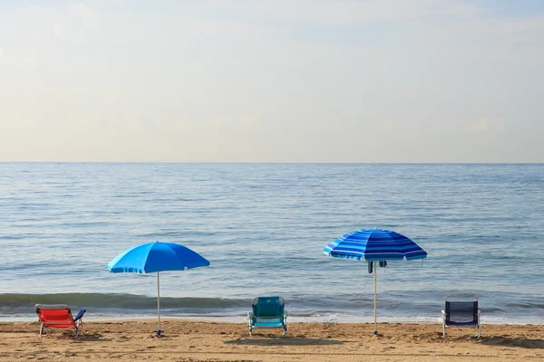 Parasols en stoelen op het strand — Stockfoto