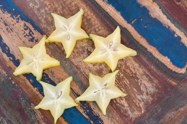Pět hvězdiček karamboly na dřevěný stůl — Stock fotografie