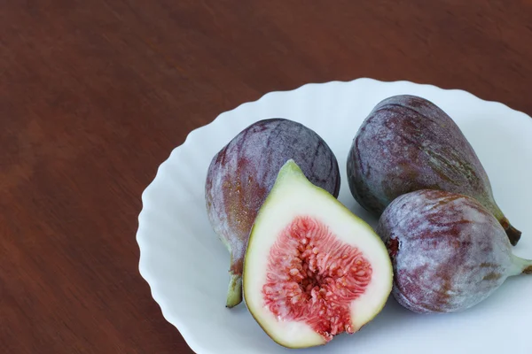 4 fresh figs on white plate on table — Stock Photo, Image