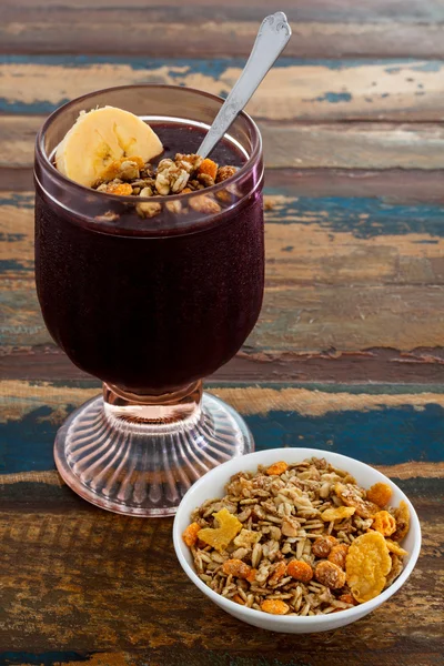 Acai in glas met muesli banaan op houten tafel — Stockfoto