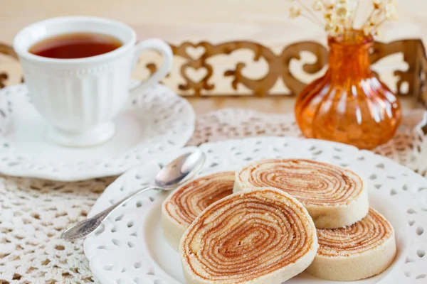 Bolo de rolo (swiss roll, rollcake) cup of tea vase on tray — Stock Photo, Image