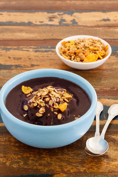 Braziliaanse dessert acai in blauwe kom met muesli en lepel 