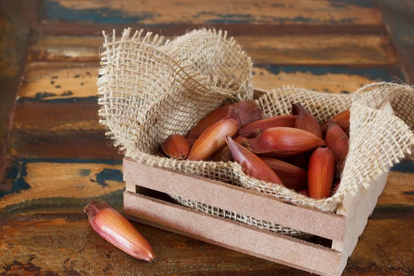 Pinhao in houten kist rouwgewaad op houten tafel — Stockfoto