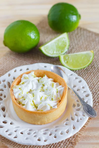 Tarta de limón en cuchara de plato blanco en saco con limón fresco — Foto de Stock