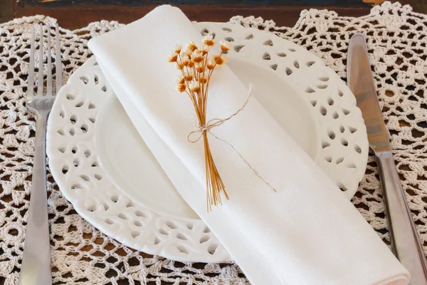 Piatto bianco coltello forchetta serviette fiori secchi all'uncinetto — Foto Stock