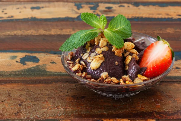 Polpa di Acai in vetro con fragola, muesli e menta fresca sul tavolo di legno — Foto Stock