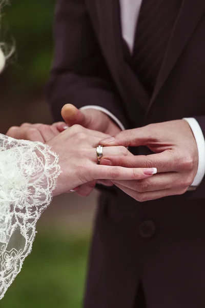 Bruidegom doet een trouwring om de vinger van de bruid — Stockfoto