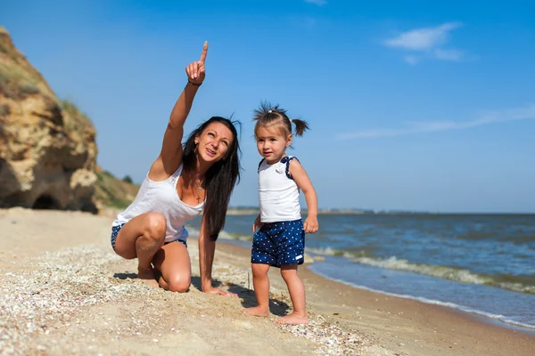 Ragazza con madre sulla spiaggia in riva al mare — Foto Stock