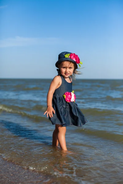 Meisje op het strand door zee — Stockfoto