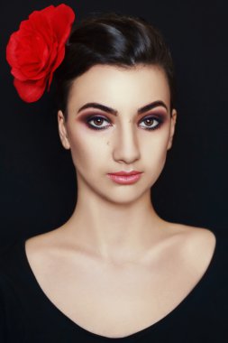 Saçında kırmızı bir çiçek bir bayanla