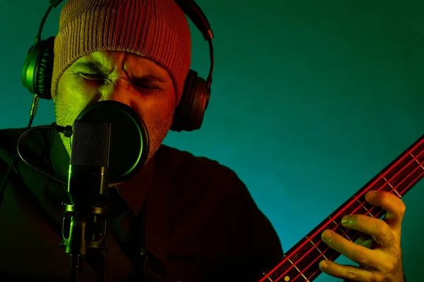 Homem Cantando Tocando Guitarra Baixo Microfone Estúdio Usando Chapéu Feito — Fotografia de Stock