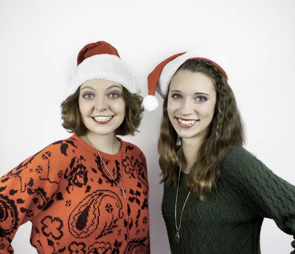 Duas jovens mulheres bonitas usando chapéus de Papai Noel — Fotografia de Stock