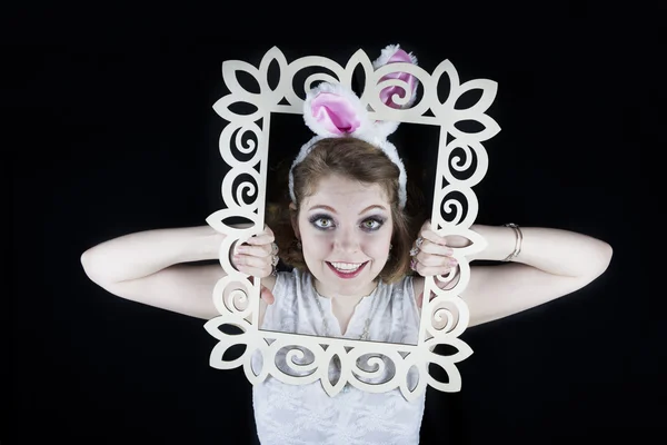 Pretty young woman with rabbit ears and picture frame — Stock Photo, Image