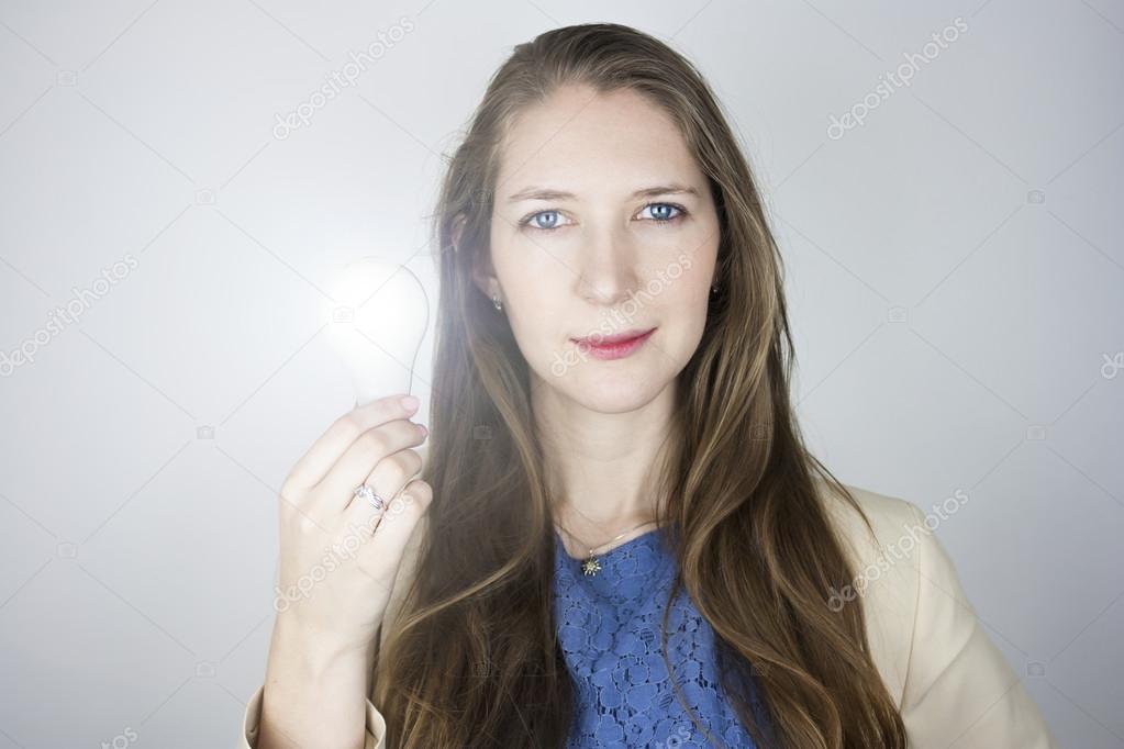 Woman holding lit light bulb