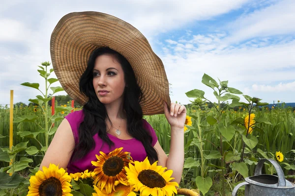 Jonge vrouw met zonnebloemen — Stockfoto