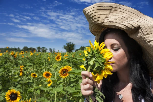 Vacker kvinna lukta solros — Stockfoto