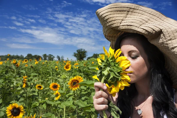 Belle femme sentant le tournesol — Photo