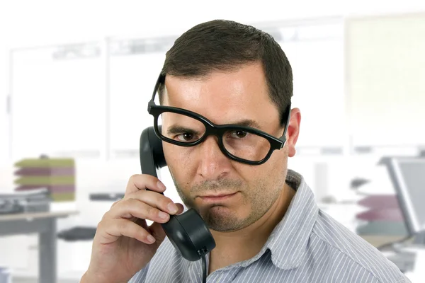 Jovem com um telefone no escritório — Fotografia de Stock