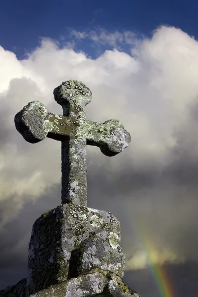 Croix de pierre dans un ciel nuageux Image En Vente