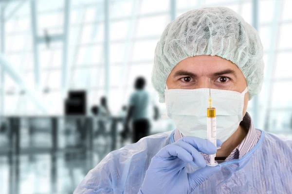 Jovem médico com máscara segurando seringa — Fotografia de Stock