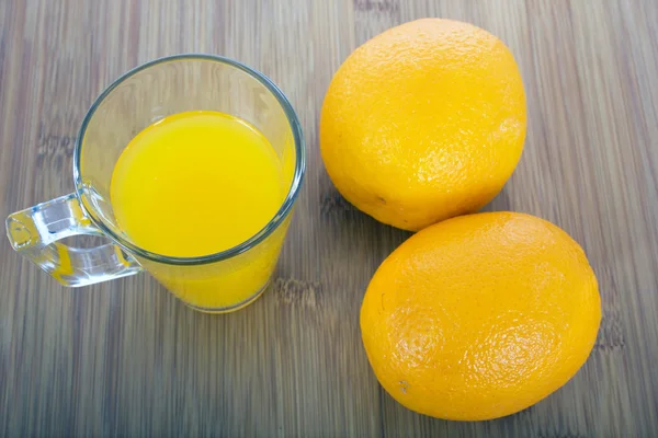 Bril van sinaasappelsap en vruchten — Stockfoto