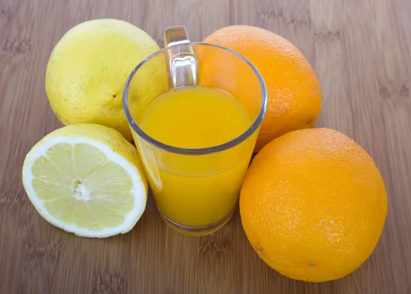 Glasplaten van sinaasappelsap en vruchten — Stockfoto
