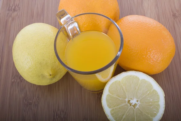 Lasillinen appelsiinimehua ja hedelmiä — kuvapankkivalokuva