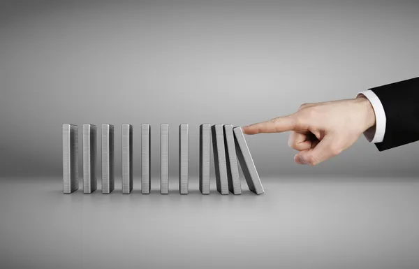 Hand trycka dominobrickor konceptet isolerade på grå bakgrund — Stockfoto