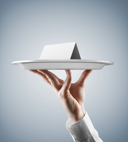 Рука держит серебряный поднос с карточкой
