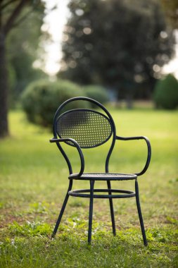 Çimenlikteki parkta yalnız tasarımcı koltuğu