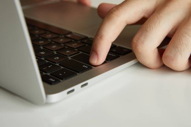 Dizüstü bilgisayarda çalışan bir adam, elleri kapalı.