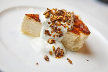 Cevizli cheesecake ve beyaz tabakta dondurma.