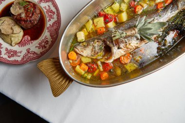 deniz levreği çorbası güzel bir tabakta sebzelerle pişirilir.