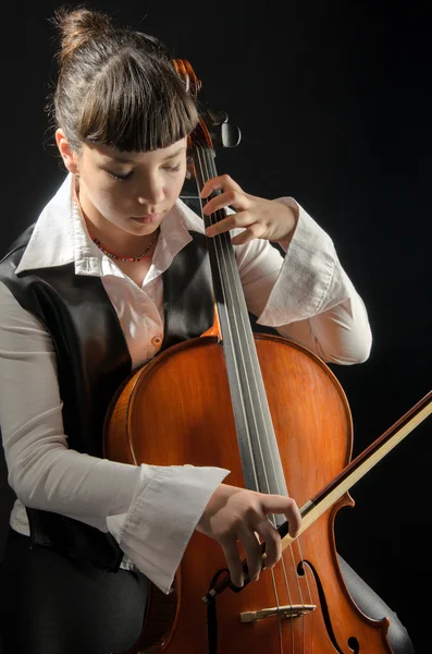 Mädchen mit Cello auf schwarzem Hintergrund — Stockfoto