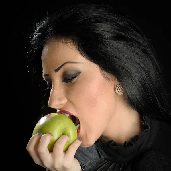 Mujer mordiendo manzana verde — Foto de Stock