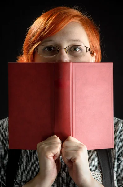 niña con libro sobre fondo negro
