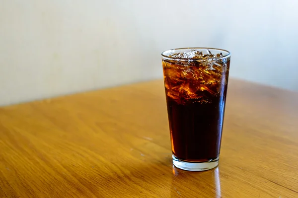 Ett glas cola med isbitar Stockbild