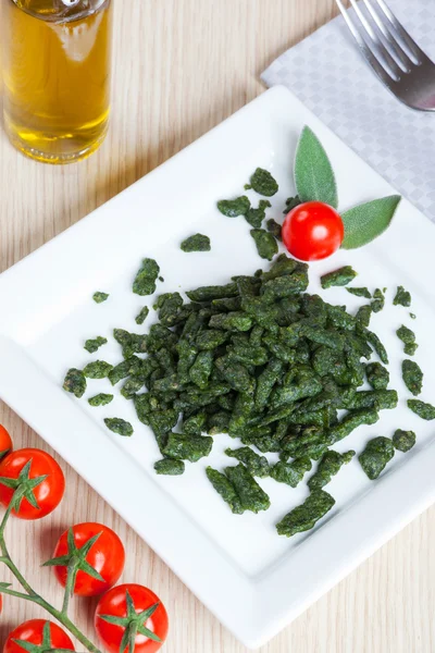 Spatzle, small dumplings with spinach and tomatoes — Stock Photo, Image