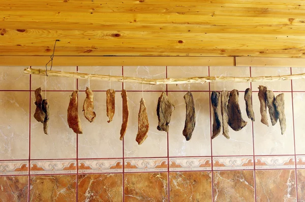 自制五香的肉干挂在木杖 — — — 图库照片