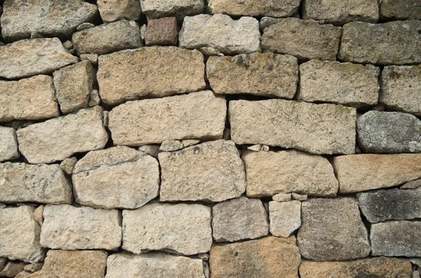 Güneşli bölgede eski beyaz taş duvar.