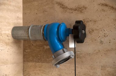 Mavi yangın musluğu ve size yakın bir ev duvarı.