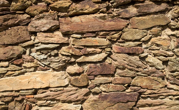 Old stone wall close up in sunny da