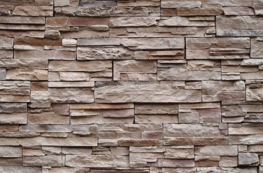 Colorful relief tiles imitating stone on wall closeu