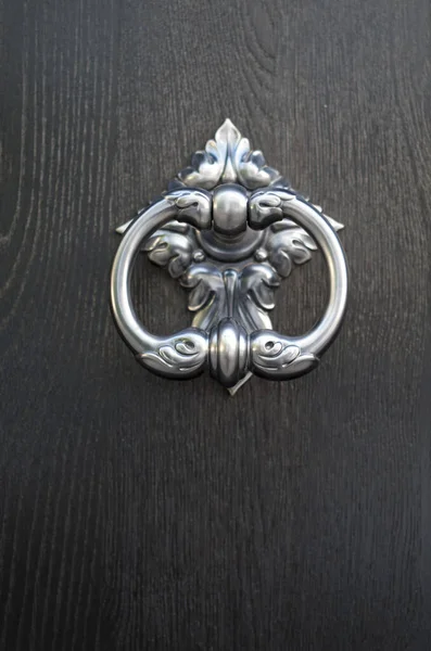 New decorative round metal door knocker on wood door closeu