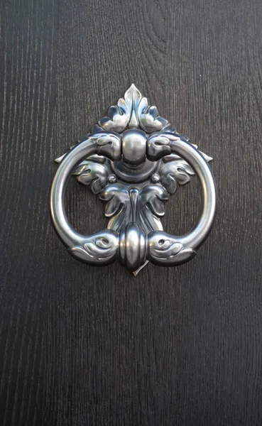 New decorative round metal door knocker on wood door closeu
